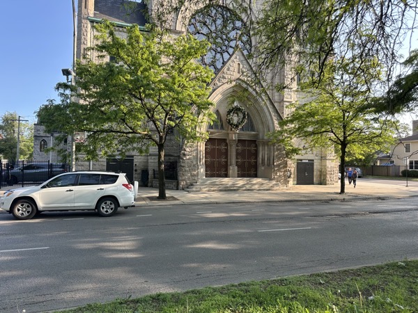 The view of Visitation/St Basic church. The door on the left is labeled “church,” the door on the right, “food pantry.” the main doors in the center are apparently not in use.