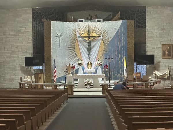 The sanctuary of the church showing the tabernacle on the original altar behind the new altar and the altar rail around teh sanctuary. Circles are a key aspect of the design language of the church