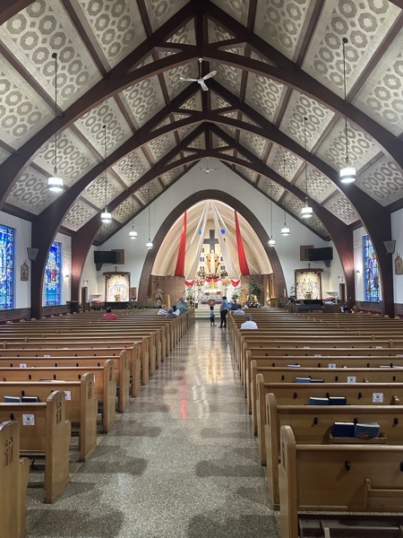 The interior of the church showing the sanctuary and the arched roof. The interior is more elegant than is typical of mid-century church buildings.