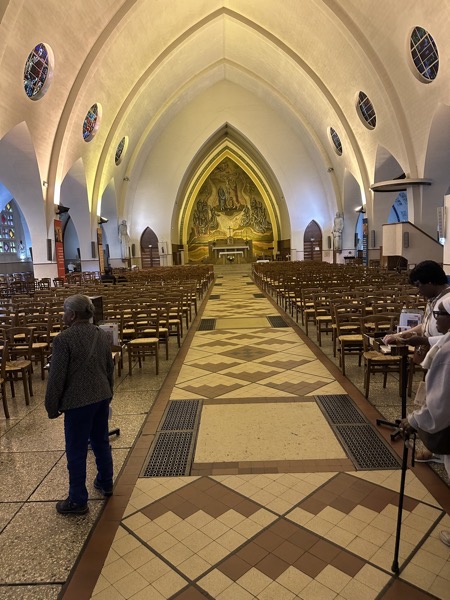 The main altar as seen from the back of the church. The church has a vaulted roof and an impressive mural on the back wall of the sanctuary.