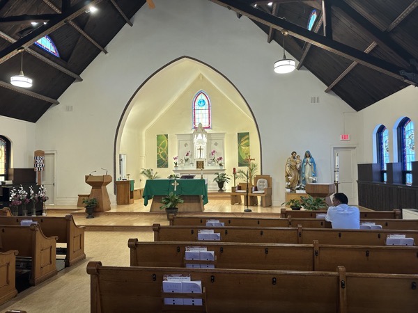The view of the sanctuary from the back of the church, showing a smallish area with a vaulted ceiling and a small arch over the sanctuary.
