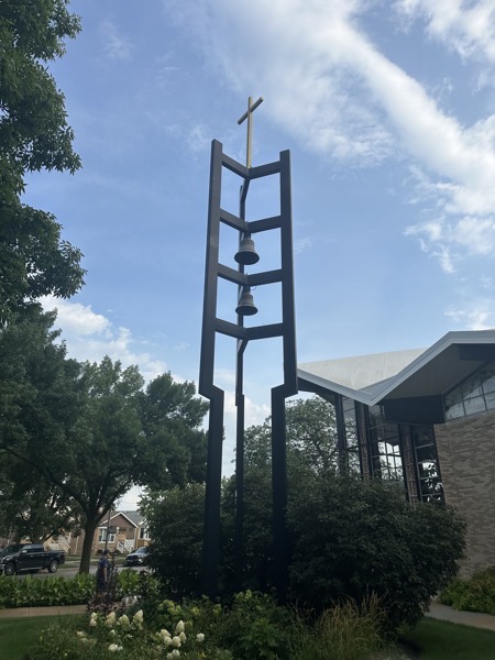 The church’s free-standing belltower which has three metal pillars which are joined by four sets of horizontal bars meeting in the center of the pillars (they would look like a Y from above). Two bells are hung from these bars with a cross at the very top of the tower. I found it striking enough that I wanted to get a picture of it on its own.
