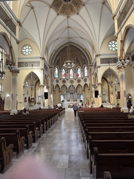 The interior of St Mary of Częstochowa, showing its gothic-styled interior including vaulted ceilings and clerestory stained glass windows. An icon of St Mary of Częstochowa is in front of the altar and just barely visible is a side-chapel which features a larger icon of St Mary of Częstochowa.