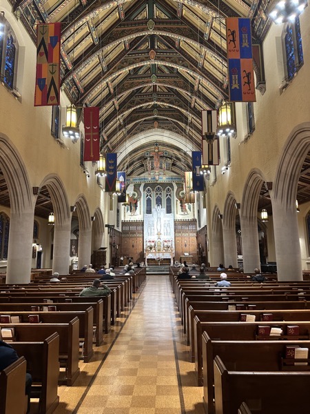 The interior of St Gregory church in a neo-Gothic style with a decorated ceiling and an ornate marble altarpiece. The bulk of the sanctuary is furnished with darkly-finished wood.