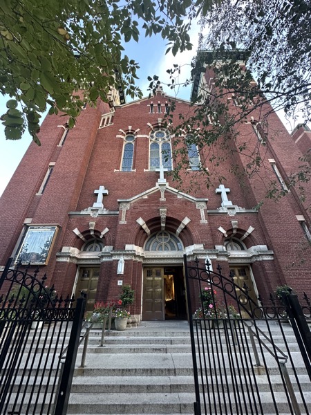 The front of the church, with a brick façade with dual bell towers 