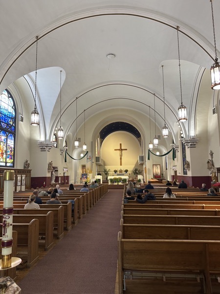 The interior of teh church with a plain white vaulted ceiling 