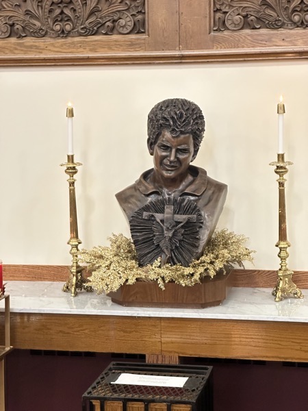A photo of a bust of Carlo Acutis at a side altar in the church