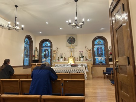 The chapel where daily Mass is held. It features a small altar, stained glass windows, statues of Mary, Joseph and a pair of angels and a tabernacle for consecrated hosts beneath a crucifix