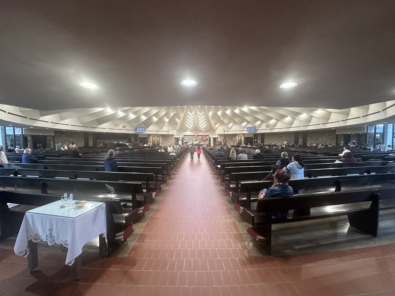 The interior of the chirch showing the wide-shallow arrangement of pews before the sanctuary