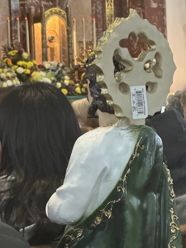 A closeup of the back of a statue with a price tag still affixed to it. There were a number of such statues of St Jude throughout the pews, looking sort of like little plaster parishioners