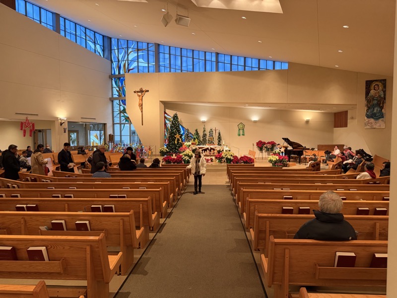 IMG_1206.jpeg The view of the sanctuary of the church. The congregation is arrayed in a semi-circle around the sanctuary, but what makes the church so daring is that the architect eschewed the temptation for symmetry for daring angles in the roof and walls of the building