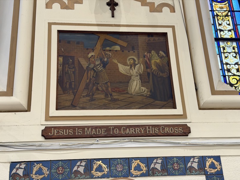 IMG_1623.jpeg The stations of the cross in the church are a series of paintings, This one is the second station, “Jesus is made to carry the cross.“ He’s not carrying it yet, but unlike the same station at Queen of the Angels church, it’s clear that he’s about to be carrying the cross rather than looking like he’s chilling out while the men behind him do the actual work
